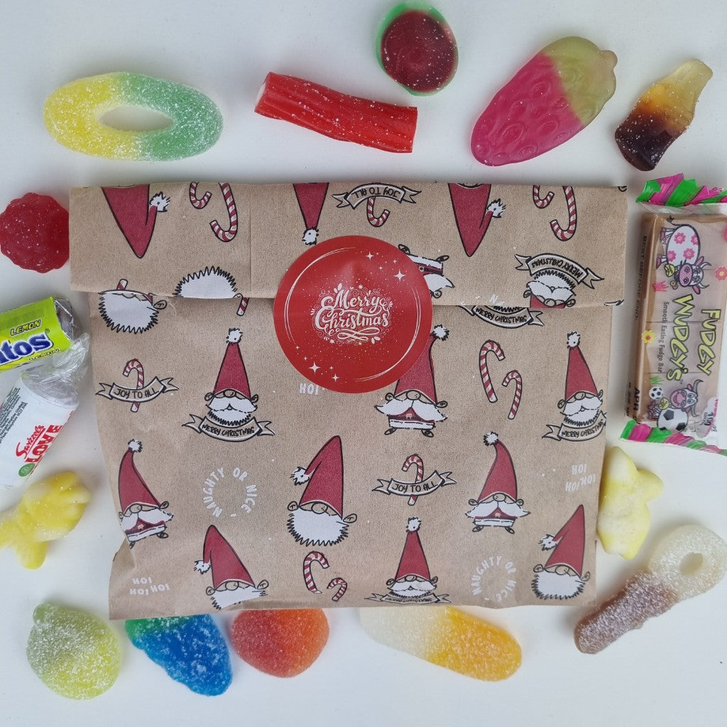 A Christmas-themed lucky bag filled with various colorful candies and a few chocolate pieces, presented on a white surface.