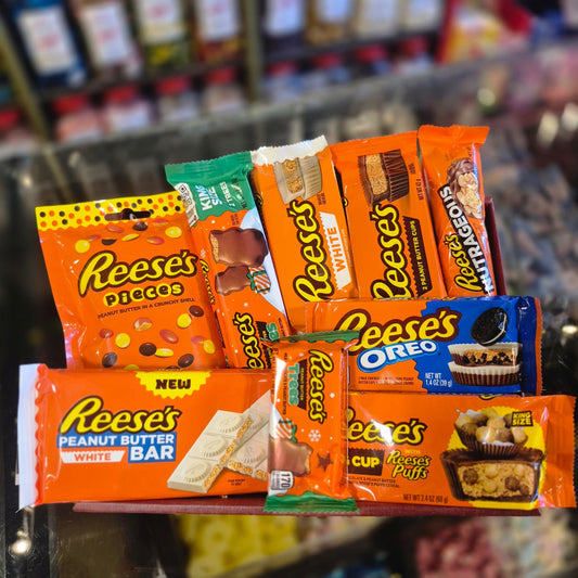 Assorted Reese's candy bars and packages on a shelf with a blurred store background