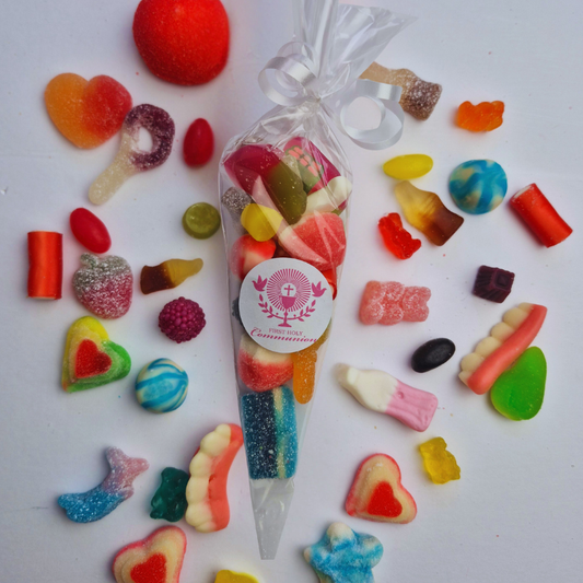 Assorted colorful candies with a clear bag featuring a first holy communion day on a white background