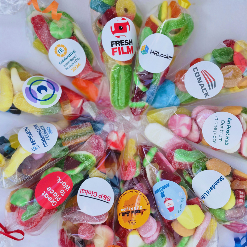 Assorted colorful candies in clear packaging with various brand stickers.