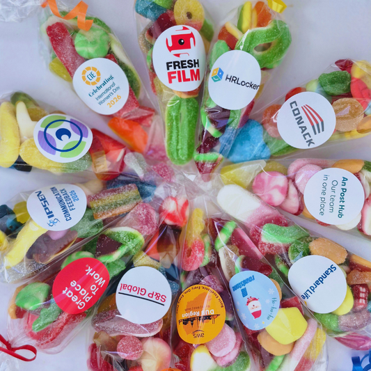 Assorted colorful candies in clear packaging with various brand stickers.