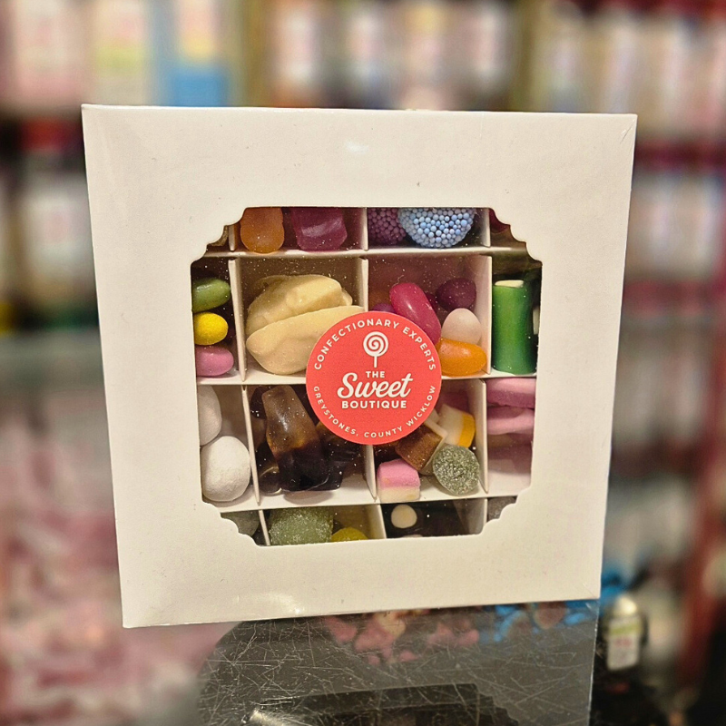 Box of assorted candies with 'The Sweet Boutique' label on a blurred background