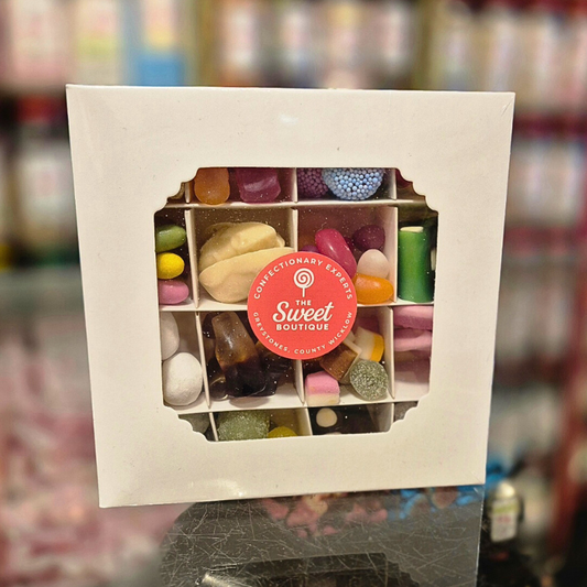 Box of assorted candies with 'The Sweet Boutique' label on a blurred background